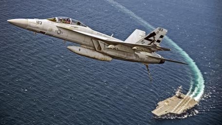 Fighter Jet Soaring Above Aircraft Carrier wallpaper
