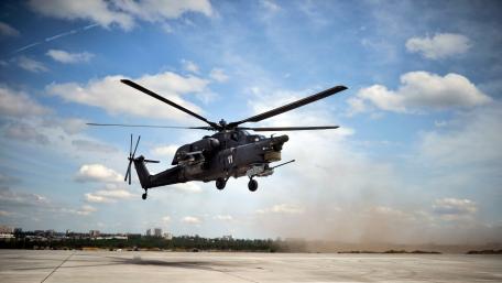 Military Helicopter in Action Above the Ground Amidst Cloudy Sky wallpaper