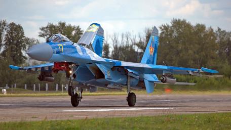 Sleek Blue Military Jet Taking Off in Graceful Maneuver wallpaper