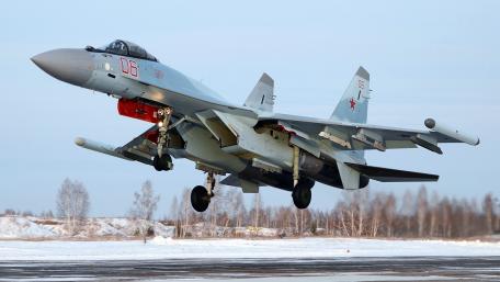 Sleek Fighter Jet in Action Amidst Snowy Landscape wallpaper