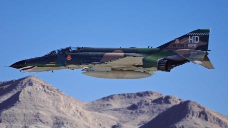 Fighter Jet in Action Above Desert Landscape wallpaper