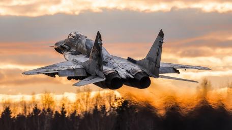 Fighter Jet in Majestic Flight Against Sunset Sky wallpaper