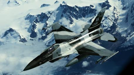 Fighter Jet Soaring Above Snowy Peaks wallpaper
