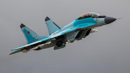 Dynamic Military Jet in Flight Amidst Dramatic Sky Conditions wallpaper
