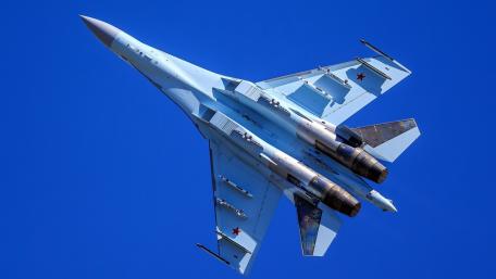 Sleek Fighter Jet in Stunning Flight Above Blue Skies wallpaper