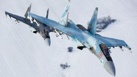 Sleek Fighters Soar Over Snowy Terrain wallpaper