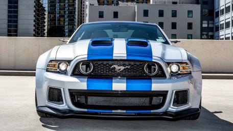 Dynamic Mustang with Striking Blue Stripes on Asphalt Surface wallpaper