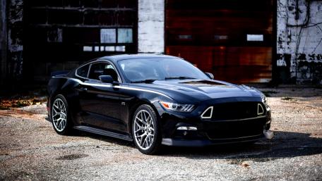 Sleek Black Muscle Car in Urban Setting wallpaper