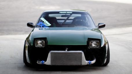 Sleek Green Sports Car Ready for Action wallpaper