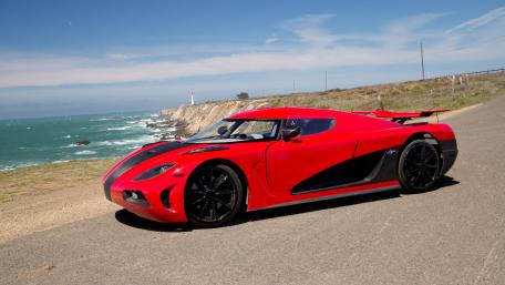 Sleek Red Supercar by the Ocean Shore wallpaper