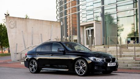 Sleek Black Car in Urban Setting wallpaper