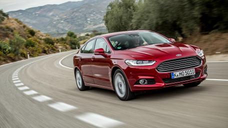 Sleek Red Car on Scenic Roadway wallpaper