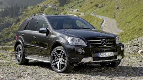 Sleek Black SUV in Nature's Embrace wallpaper