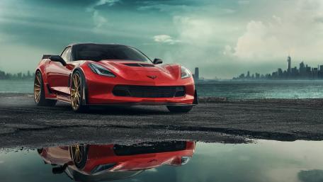 Red Corvette in Urban Landscape Reflection wallpaper