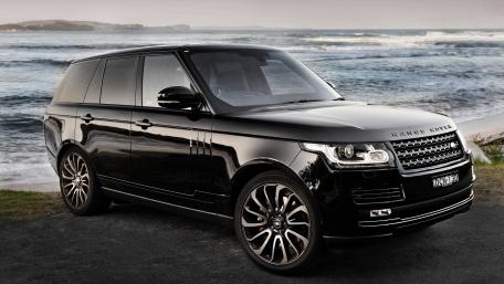 Sleek Black SUV Against Coastal Background wallpaper