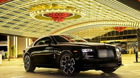 Sleek Black Luxury Car Under Bright Lights wallpaper