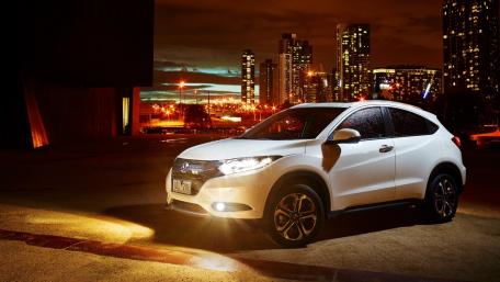 Sleek White Car Against City Skyline at Night wallpaper