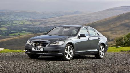 Sleek Silver Luxury Car on Scenic Landscape 4K Wallpaper wallpaper