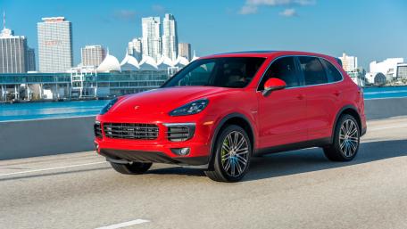 Sleek Red Luxury SUV in Urban Landscape wallpaper