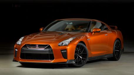 Sleek Orange Sports Car in Dark Setting wallpaper
