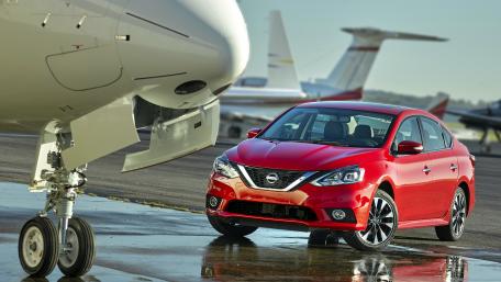 Sleek Red Sedan by the Runway wallpaper