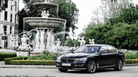 Elegant BMW by Fountain in Luxurious Setting wallpaper