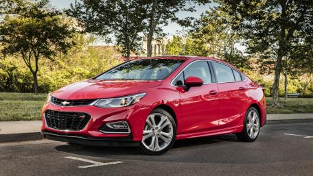 Sleek Red Sedan in a Scenic Urban Setting wallpaper