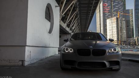 Sleek Black BMW Under Urban Overpass wallpaper