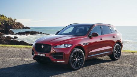 Sleek Jaguar SUV by the Ocean Shoreline wallpaper