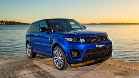 Sleek Blue SUV by the Water at Sunset wallpaper