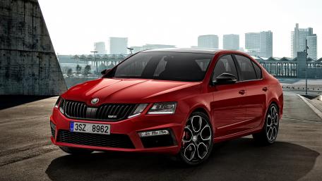 Sleek Red Sedan in Urban Setting wallpaper