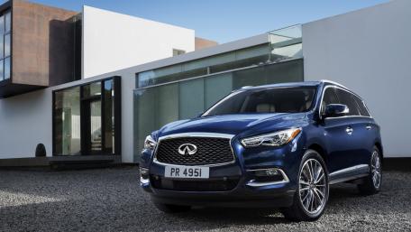 Sleek Infinity SUV Against Modern Architecture wallpaper