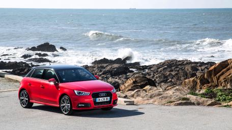 Vibrant Red Audi by the Ocean Shore wallpaper