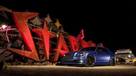 Sleek Car amidst Neon Lights and Vintage Signage wallpaper