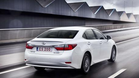 Sleek White Sedan on a Rainy Road wallpaper