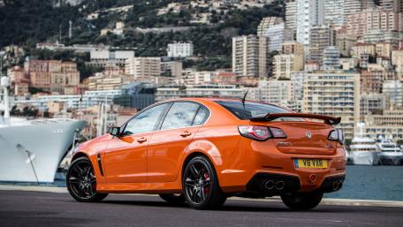 Vibrant Orange Sports Car by the Marina wallpaper