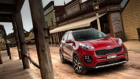 Vibrant SUV in Rustic Town Scene wallpaper