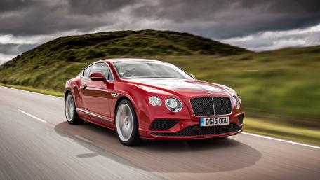 Sleek Red Bentley in Motion on Scenic Roadway wallpaper