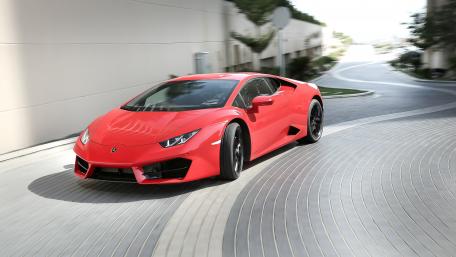 Dynamic Red Lamborghini on Curved Roadway wallpaper