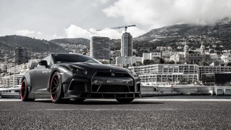 Sleek Black Sports Car on Cityscape Background wallpaper