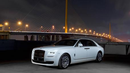 Elegant White Luxury Car Under City Lights at Night wallpaper