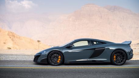 Sleek McLaren Supercar on Desert Roadway wallpaper