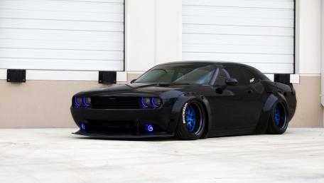 Sleek Black Muscle Car with Stunning Blue Accents wallpaper