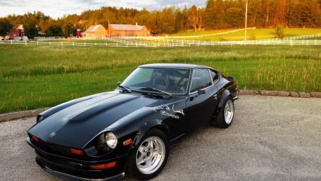 Classic Black Sports Car in Nature's Embrace wallpaper
