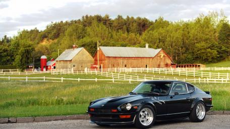 Classic Car Amidst Serene Countryside Setting wallpaper