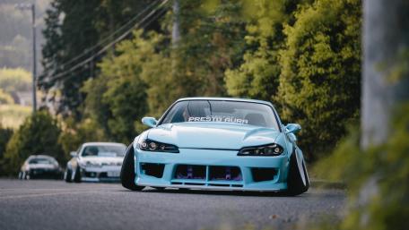 Sleek Blue Sports Car on a Scenic Roadway wallpaper