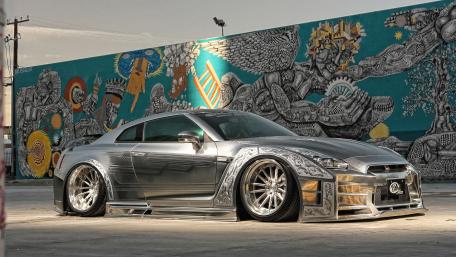 Sleek Silver Car Against Vibrant Mural Backdrop wallpaper