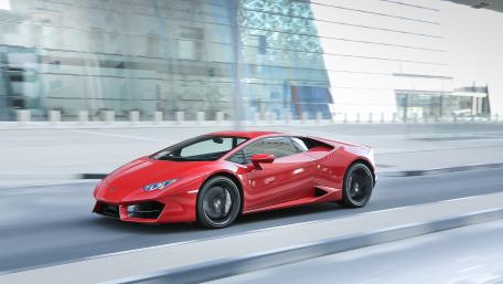 Sleek Red Sports Car in Motion on Urban Roadway wallpaper