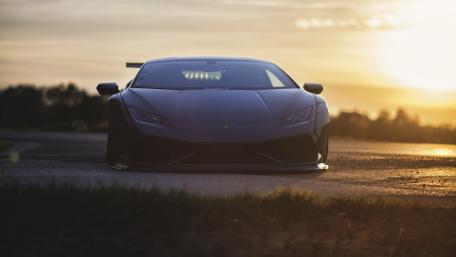 Sleek Black Luxury Car Against a Sunset Sky wallpaper