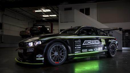 Sleek Black Racing Car in a Modern Garage wallpaper